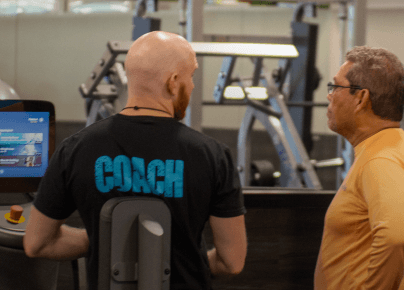 Coach talking to an older man at the gym