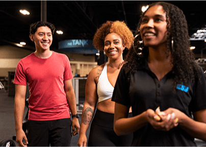 eos staff giving tour of gym to two smiling guests