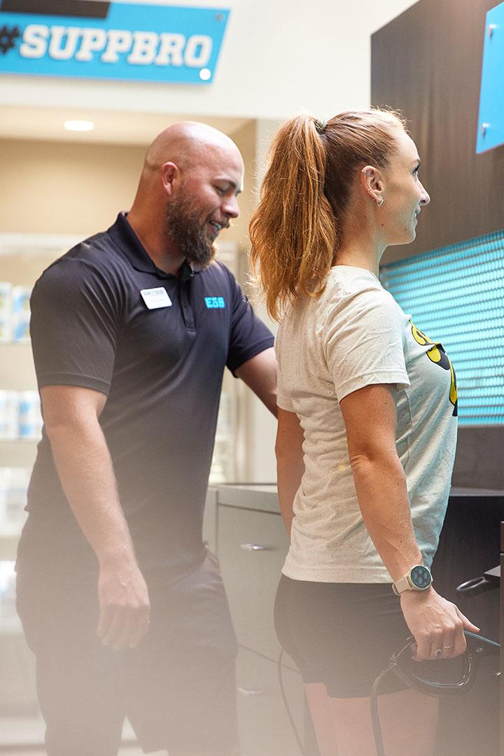 eos staff helping gym member with evolt scanner