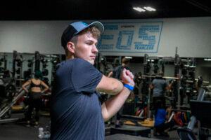 Man stretching his arm in the gym