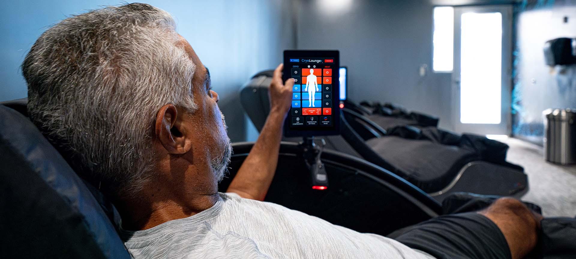 an eos gym member adjusting the settings to his cryo chair via a digital panel