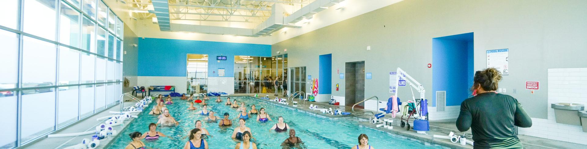 full indoor pool with instructor leading them on