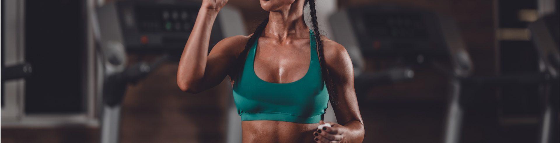 an athletic woman drinking water