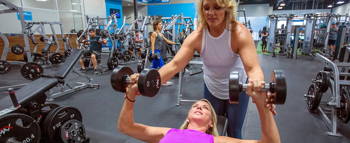 Two women working out at an EōS fitness gym