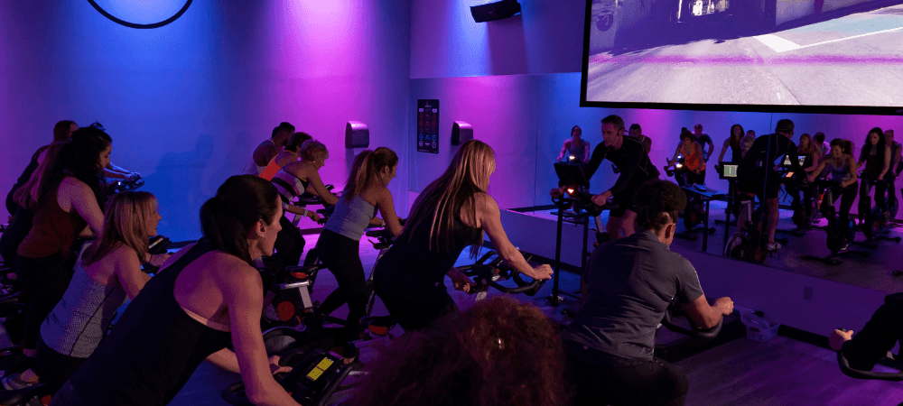 group of athletic eos gym member in a vibrant cycling class