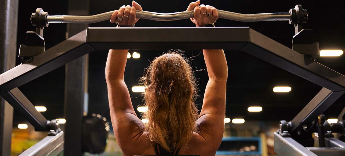 eos member lifting a barbell overhead