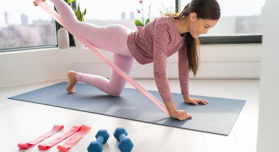 athletic person performing resistance band fitness at home