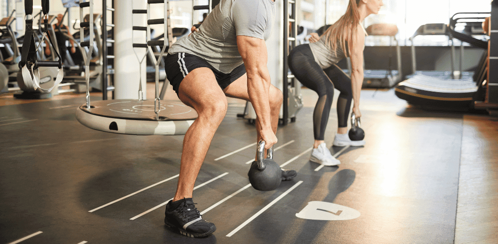 two athletic gym members performing a lower body free weight workout