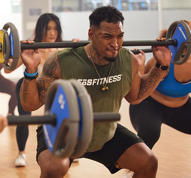 A group of eos gym members lifting barbells during a fitness class