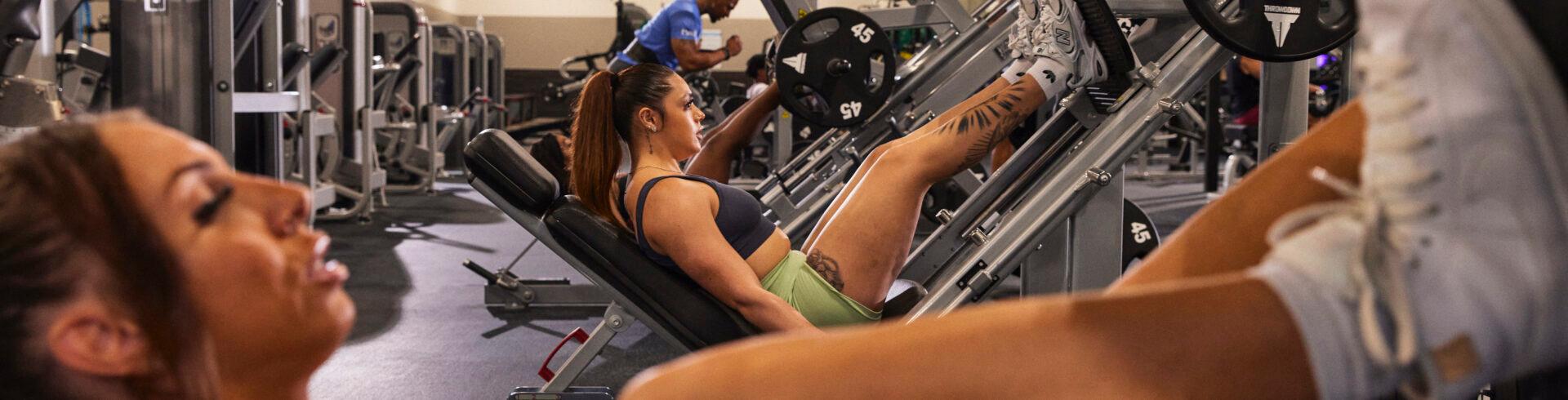 a group of athletic eos gym members on modern leg press machines