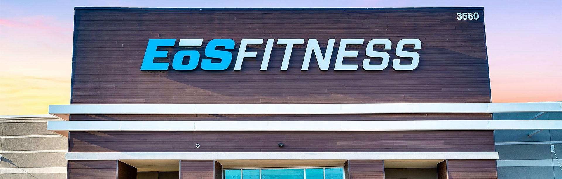 outside shot of a modern eos fitness gym with brick walls and bright blue branding