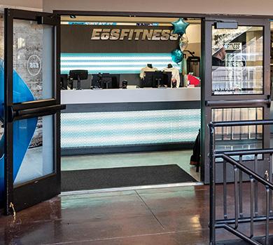 outside shot of a modern eos gym with brick walls and bright blue branding