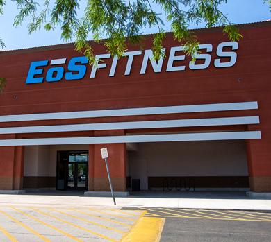 outside shot of a modern eos gym with brick walls and bright blue branding