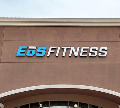 outside shot of a modern eos gym with brick walls and bright blue branding