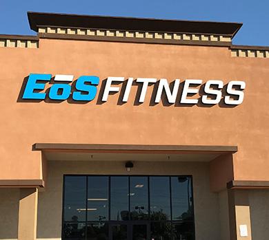 outside shot of a modern eos gym with brick walls and bright blue branding