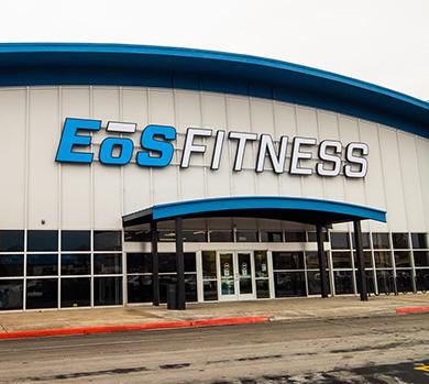 outside shot of a modern eos gym with brick walls and bright blue branding