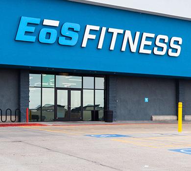 outside shot of a modern eos gym with brick walls and bright blue branding
