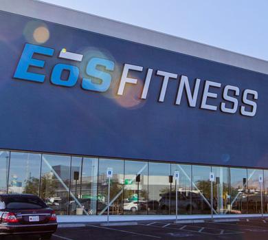 outside shot of a modern eos gym with brick walls and bright blue branding