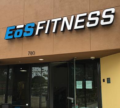 outside shot of a modern eos gym with brick walls and bright blue branding