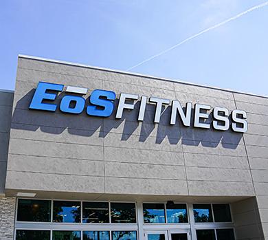 outside shot of a modern eos gym with brick walls and bright blue branding