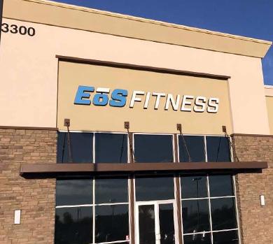 outside shot of a modern eos gym with brick walls and bright blue branding