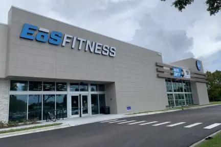 Outside view of an EōS Fitness gym with sleek gray walls and prominent blue signage