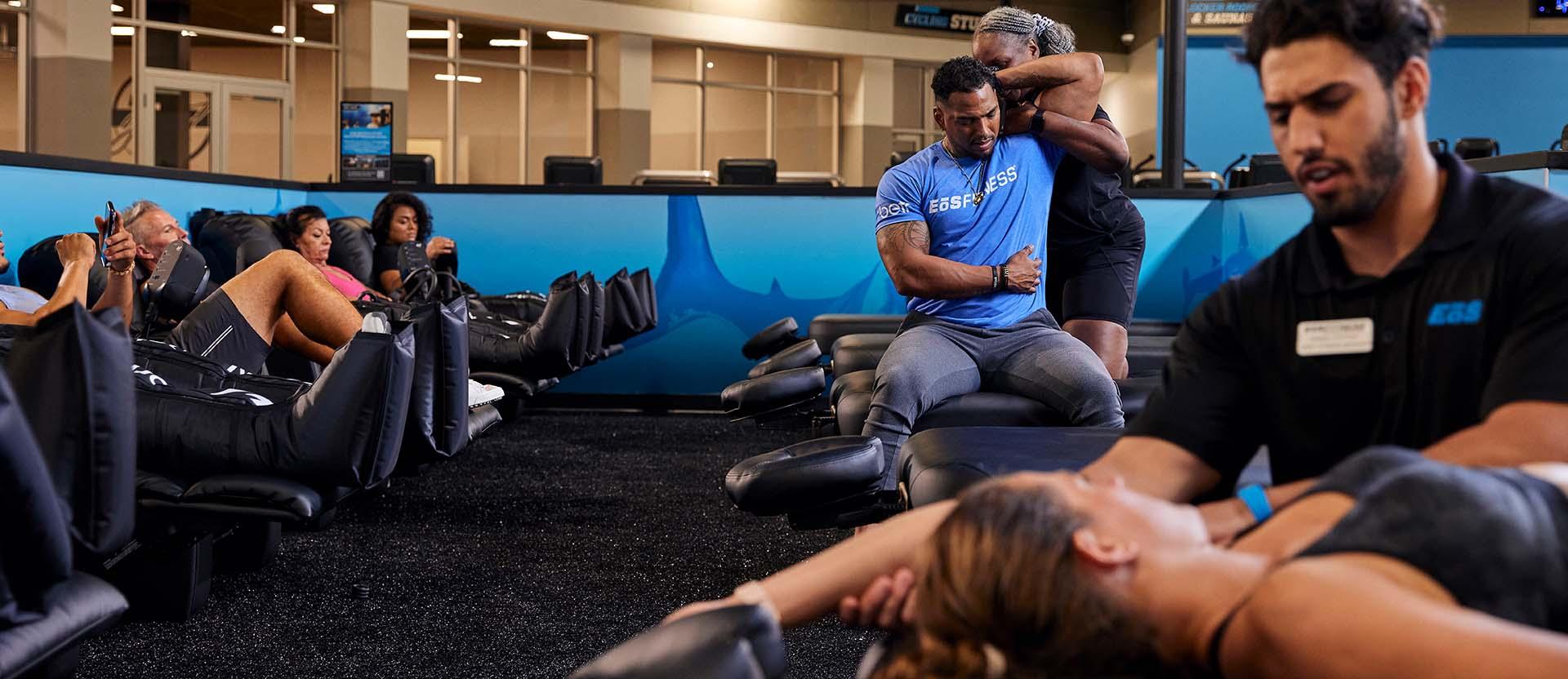 a group of eos members on recovery massage chairs and getting stretched out by staff