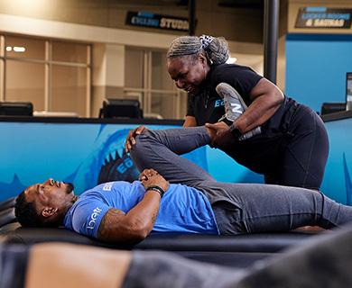 eos member laying on table and getting their leg stretched out by eos staff