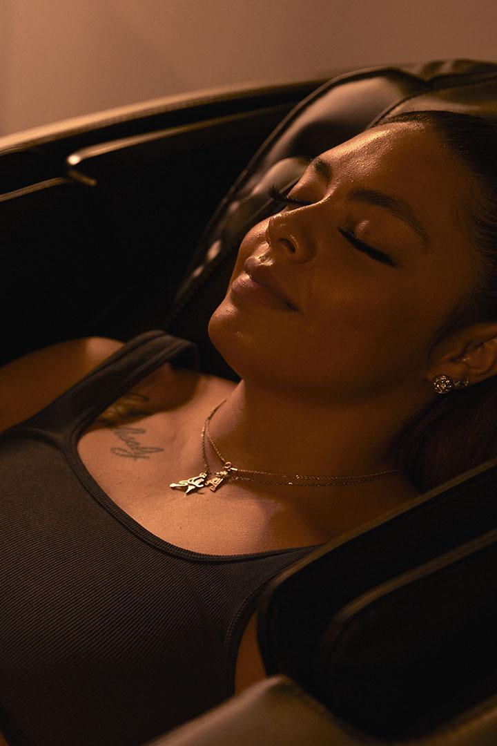 eos gym member smiling and resting inside a recovery chair