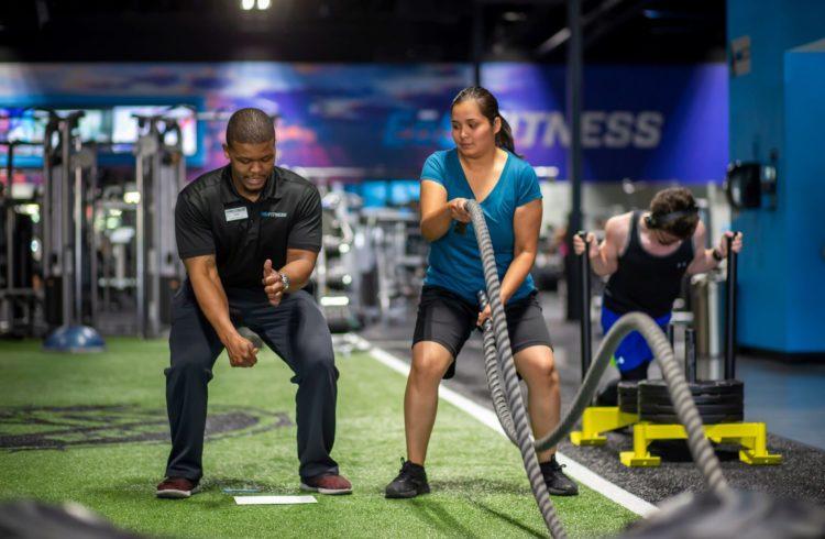 personal trainer showing eos gym member Proper Technique on battle ropes