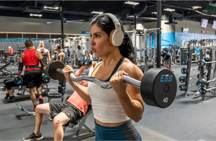 a gym full of eos gym members doing different barbell exercises