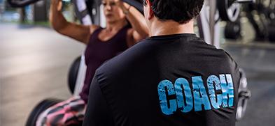 expert coach monitoring eos member on chest press machine