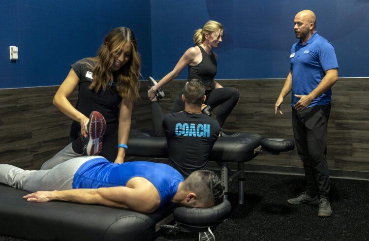 eos staff stretching out eos gym members on tables in the tank