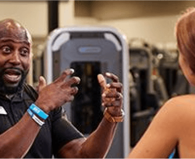 personal trainer explaining a workout to eos gym member inside of a eos branded box gym