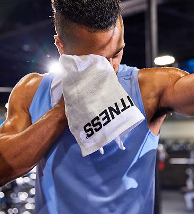 eos member in blue tank top wiping off sweat after hard workout