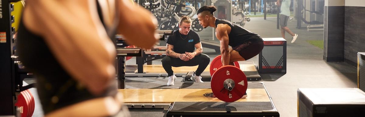 eos gym member getting help with deadlifts with coach