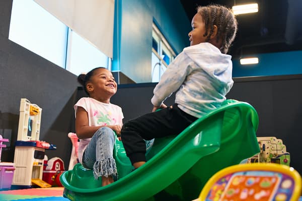 Child enjoying supervised play at EōS Kids’ Club while parents work out