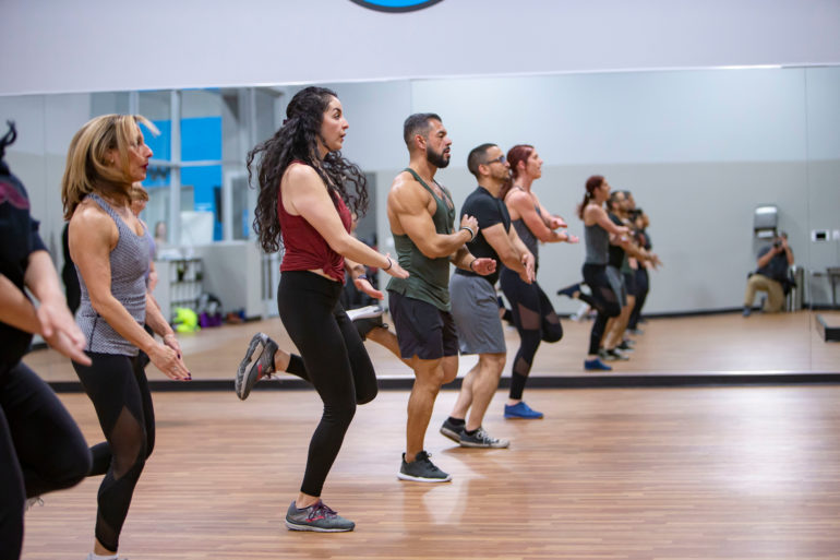 People jumping, taking a cardio group fitness class
